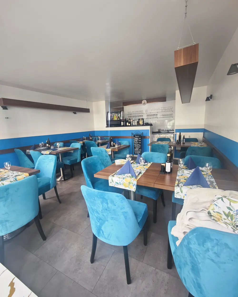 Gastraum von La Pasteria mit blauen Samtstühlen und gedeckten Tischen