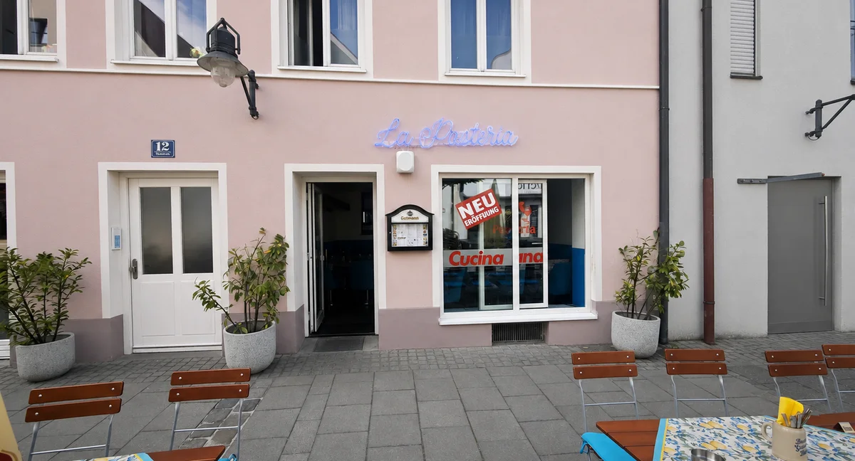 Fassade von La Pasteria in der Dollstraße 12 mit Leuchtschild und Außenterrasse